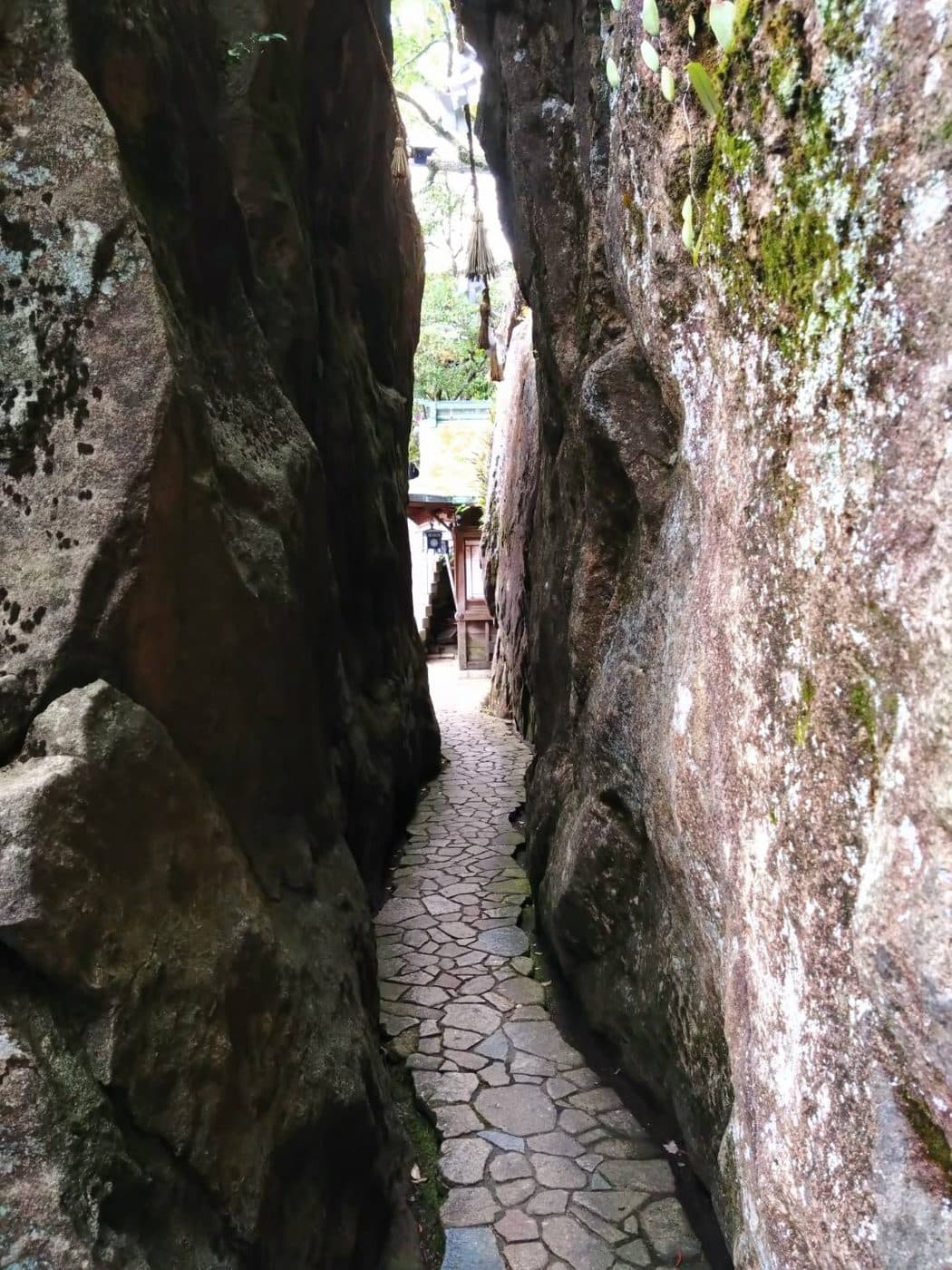 巨大な岩と岩の隙間を抜ける、石畳の細い参道