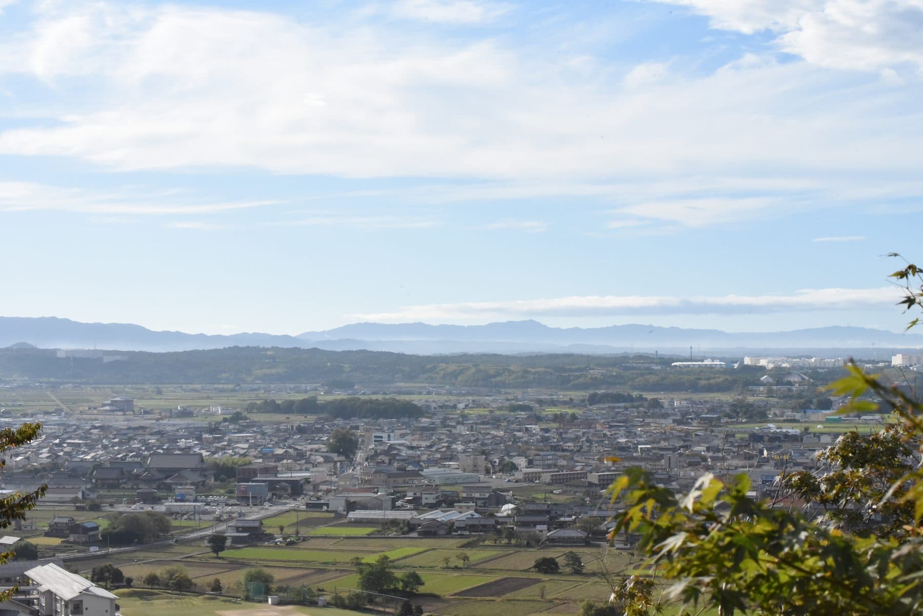 舞台から望む近江平野の大パノラマ。田畑と町並みが広がり、遠くに山並みが見える